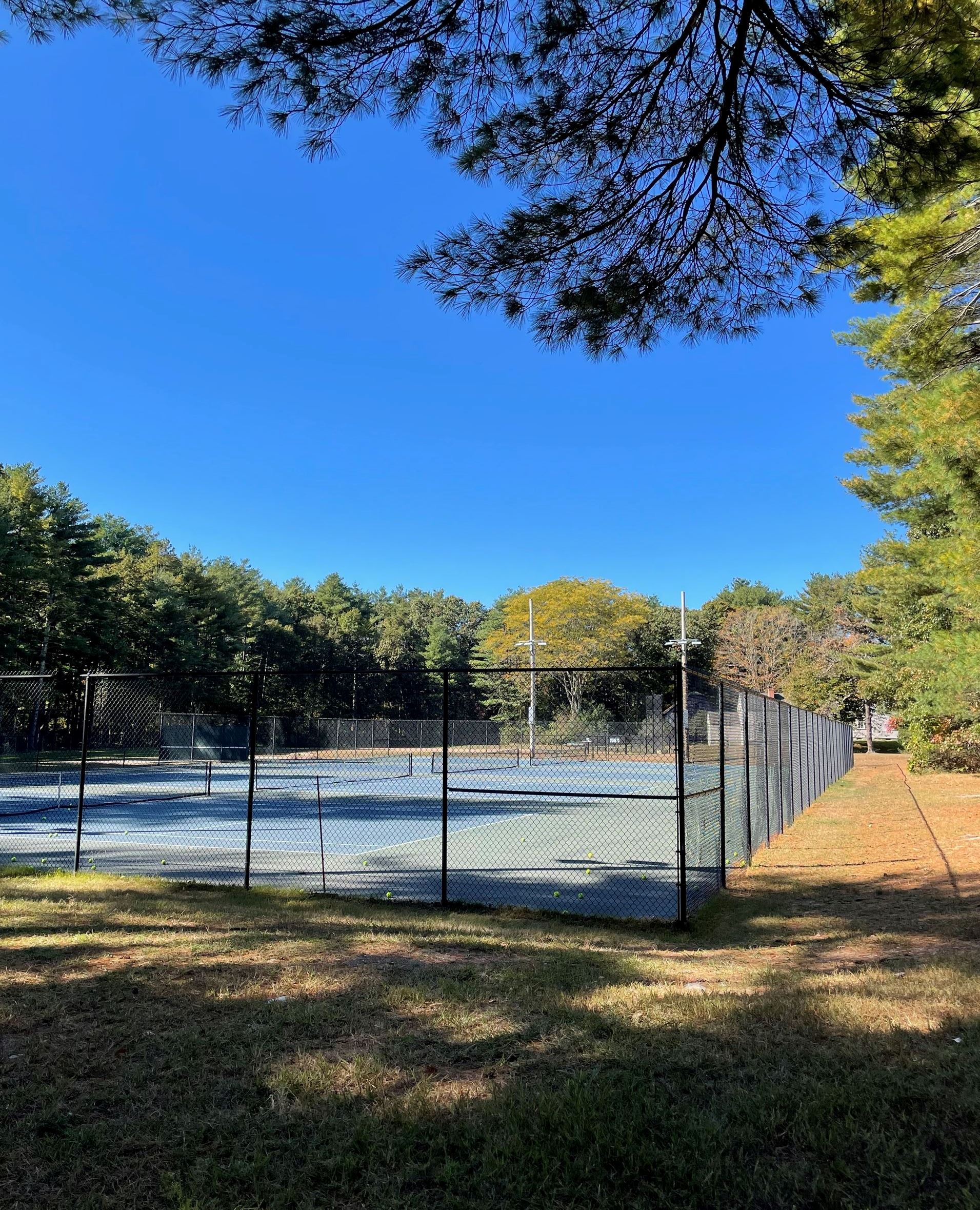 Photo of tennis courts with balls in the court