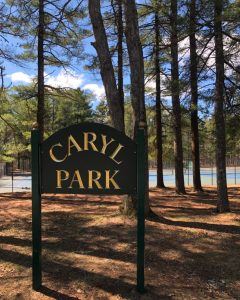 outdoor wooden sign in rural area reading Caryl Field