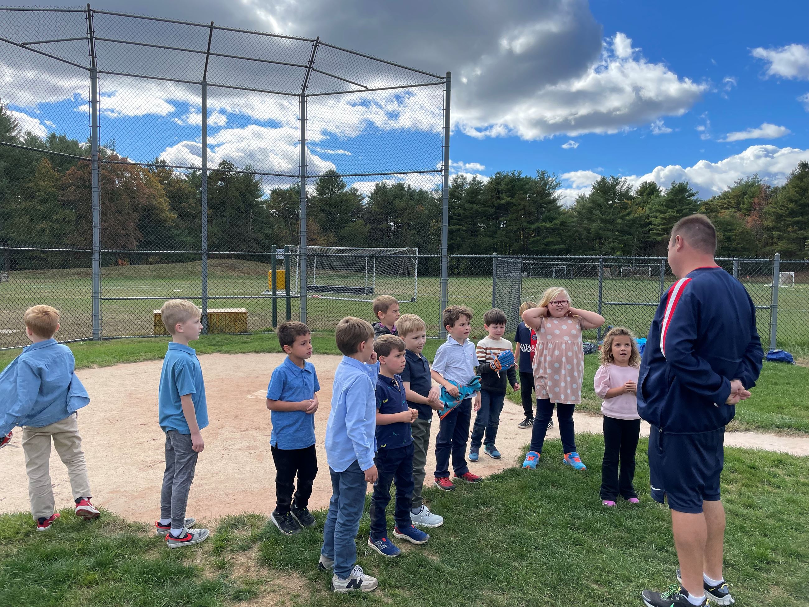 Photo of children circled up with Coach Pete