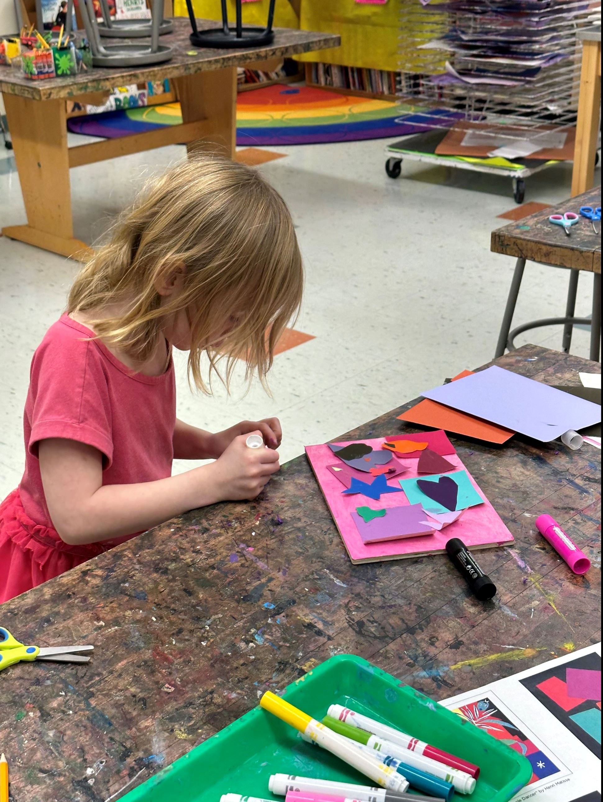 Photo of child looking down and coloring in an art project